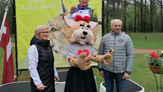 Cilvēki uz apbalvošanas pjedestāla