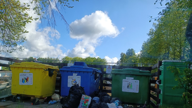 Atkritumu konteineri un samēslota apkārtne