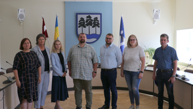 vairāki cilvēki stāv pie karoga