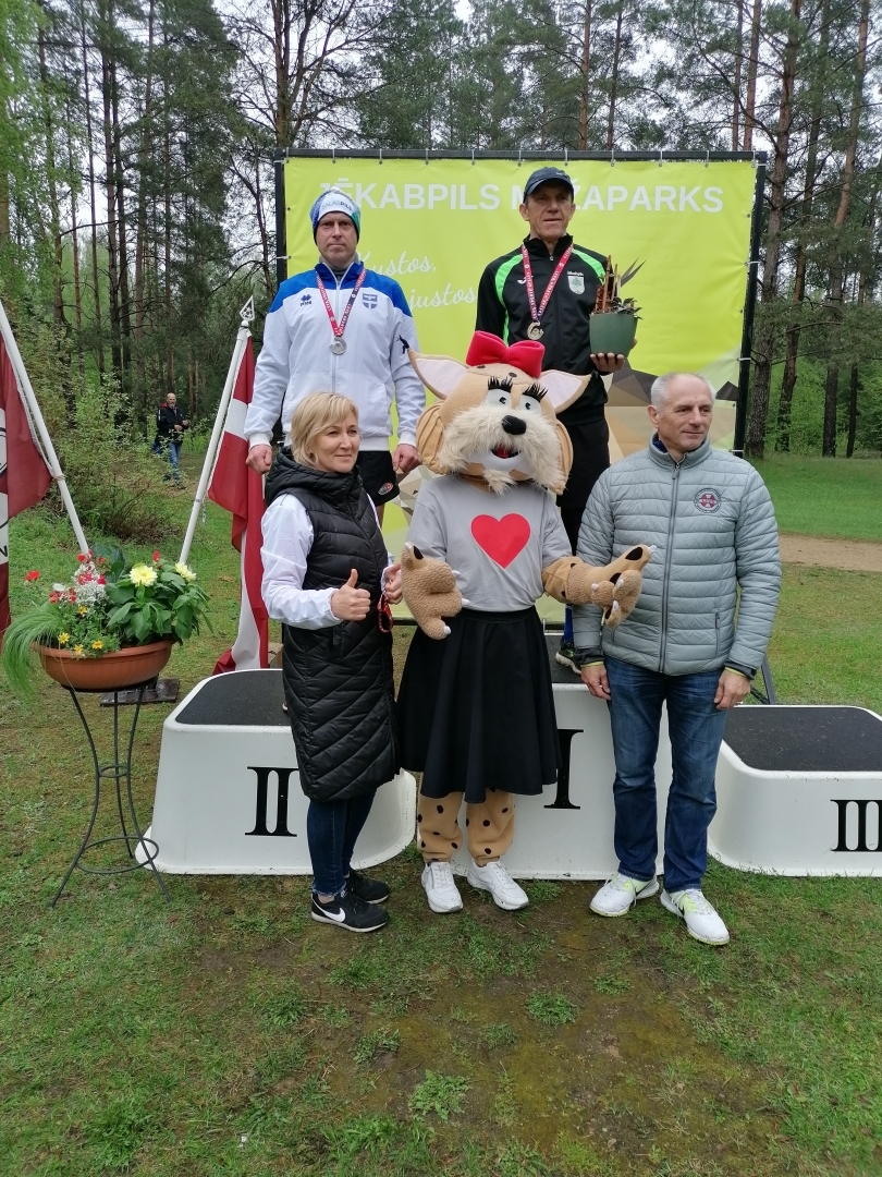 Cilvēki uz apbalvošanas pjedestāla