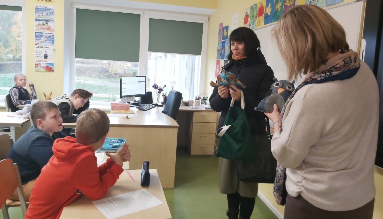 Divas sievietes ar šūtiem auduma kaķiem rokās