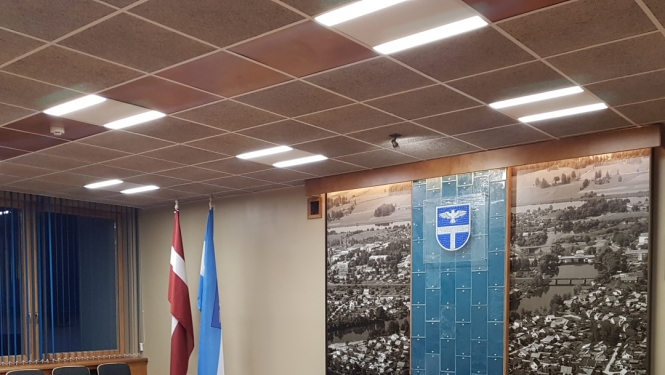 zāle ar ovālu galdu un krēsliem apkārt