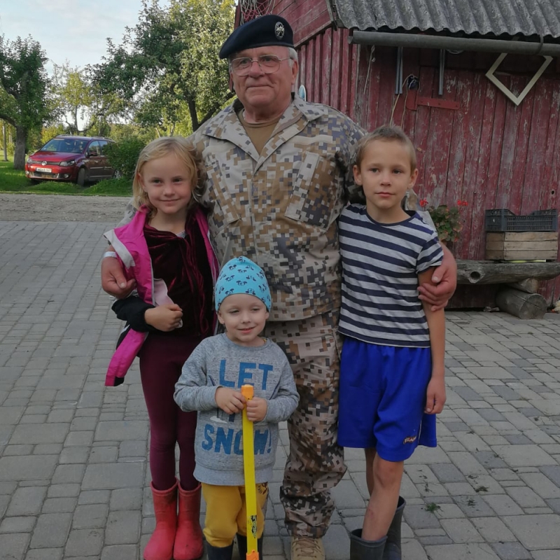 Vīrietis zemessarga formā un trīs bērni