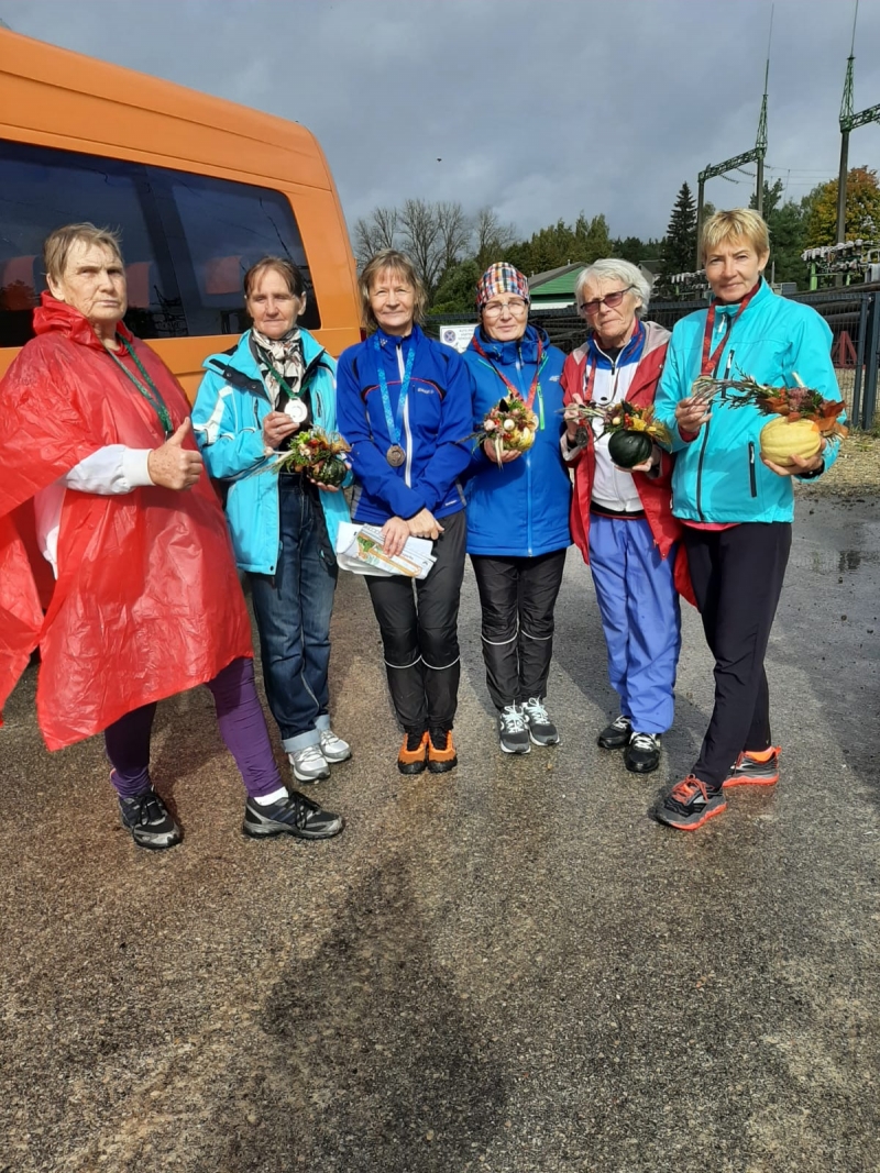 Sievietes ar balvām pie autobusa