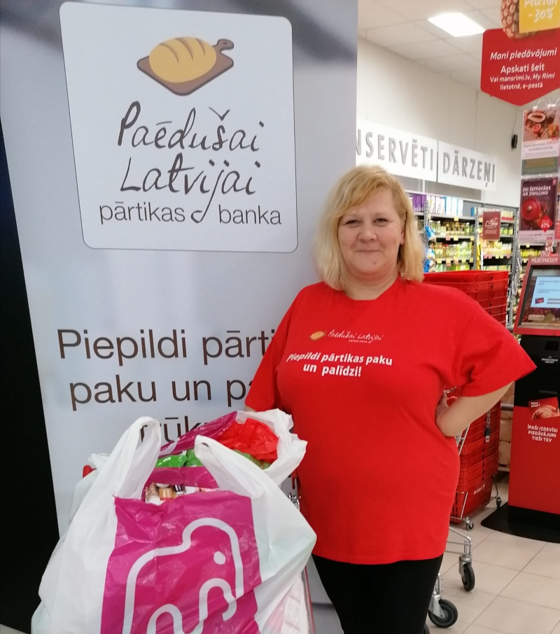 Sieviete sarkanā t-kreklā veikalā
