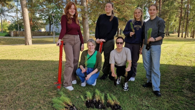  6 meitenes ar jaunajiem priežu stādiem rokās 