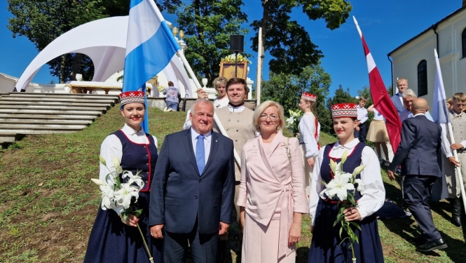 daudz cilvēki svinīgi, ar karogiem