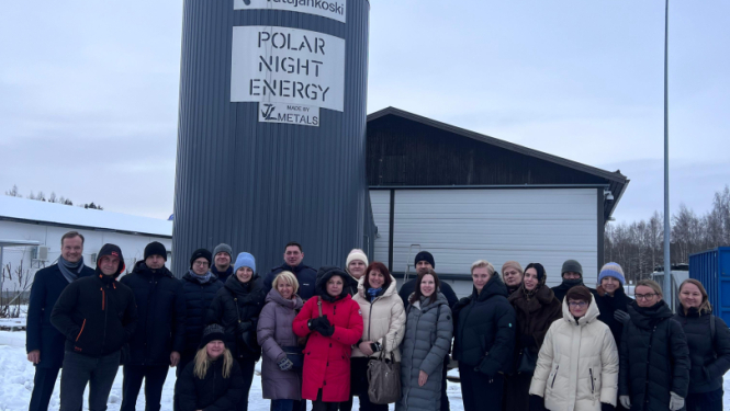 daudz cilvēku stāv pie ēkas ziemā