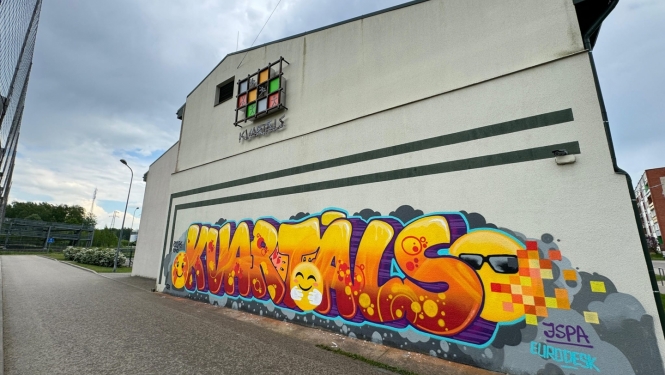 dzeltens grafiti uz mājas sienas