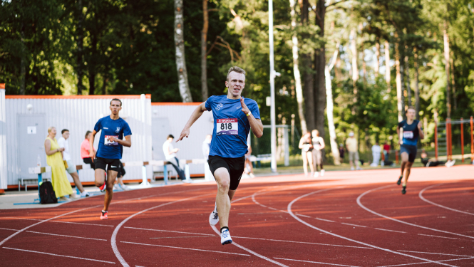 Jaunieši skrien stadionā (centrā Nīls Jakovels)