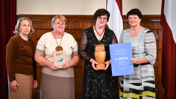 Četras sievietes ar koka pūci un diplomu