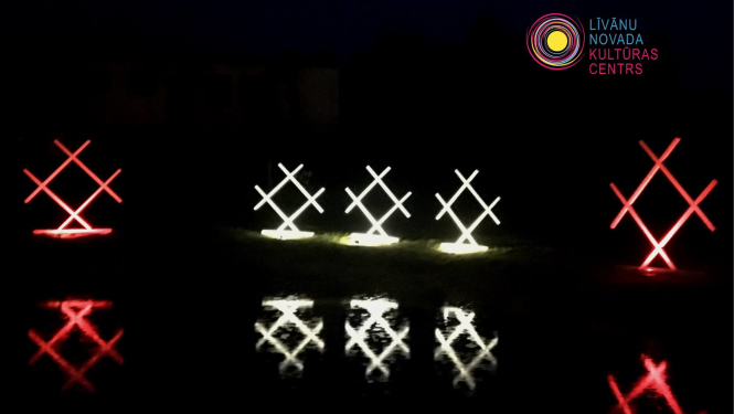 Izgaismoti ornamenti tumsā 