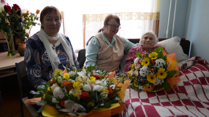 Trīs sievietes ar ziediem