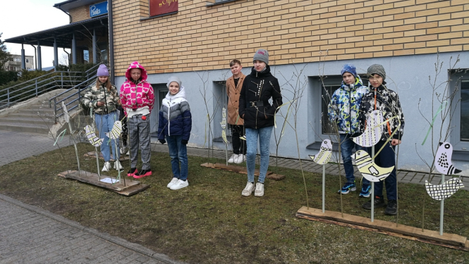 Bērni pie rotājumiem pie ēkas