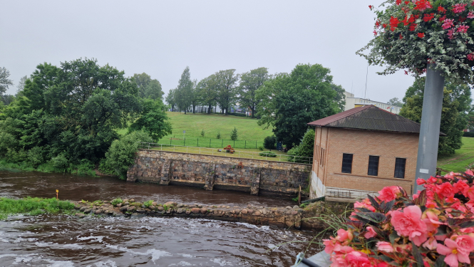 upe un ķieģelu māja krastā