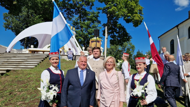 daudz cilvēki svinīgi, ar karogiem