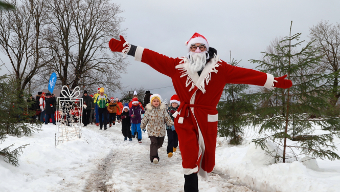 ziemassvētku vecītis skrien pa priekšu un iedzīvotāji aiz viņa