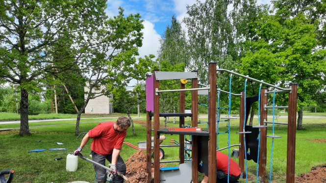 Celtnieki uzstāda jaunu bērnu rotaļu laukumu