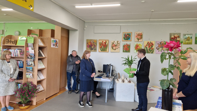 daudz cilvēku sveic ar ziediem