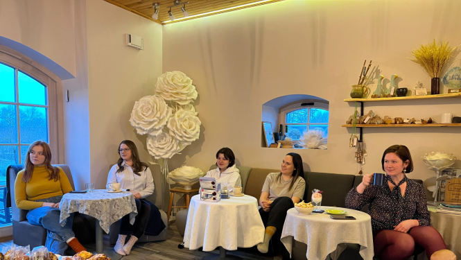 cilvēki sēž ap galdu