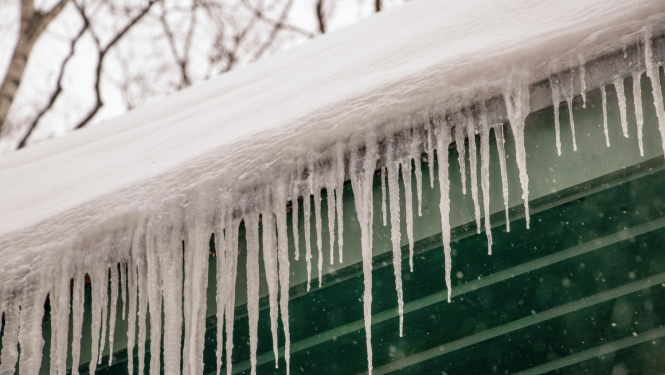 Sniegs un lāstekas uz mājas jumta