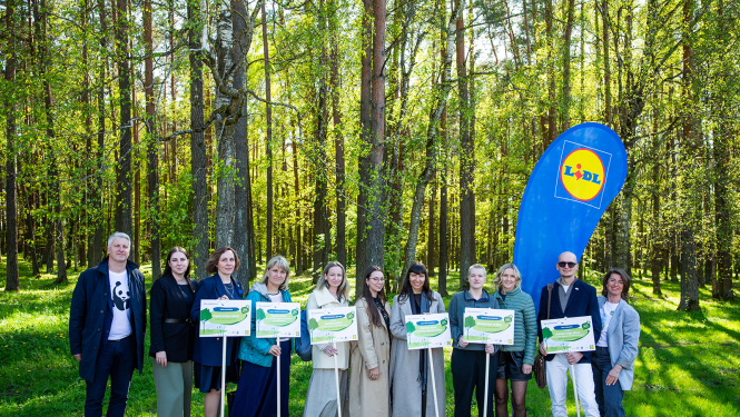 daudz cilvēki stāv ar plakātiem dabā pie meža