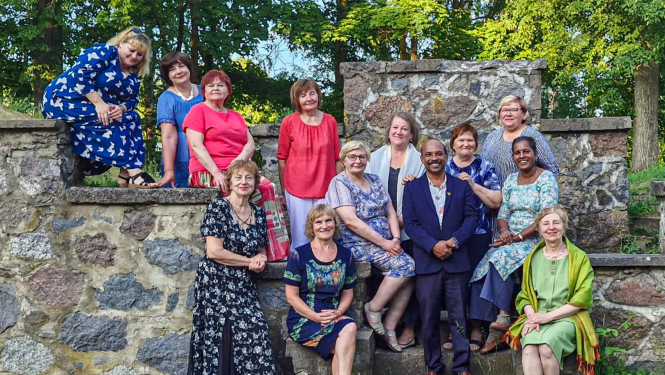 daudz cilvēki stāv pie akmeņu sienas