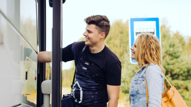 divi cilvēki kāpj satiksmes autobusā