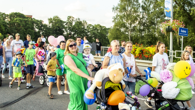 daudz cilvēku gājienā, bērni ratiņos