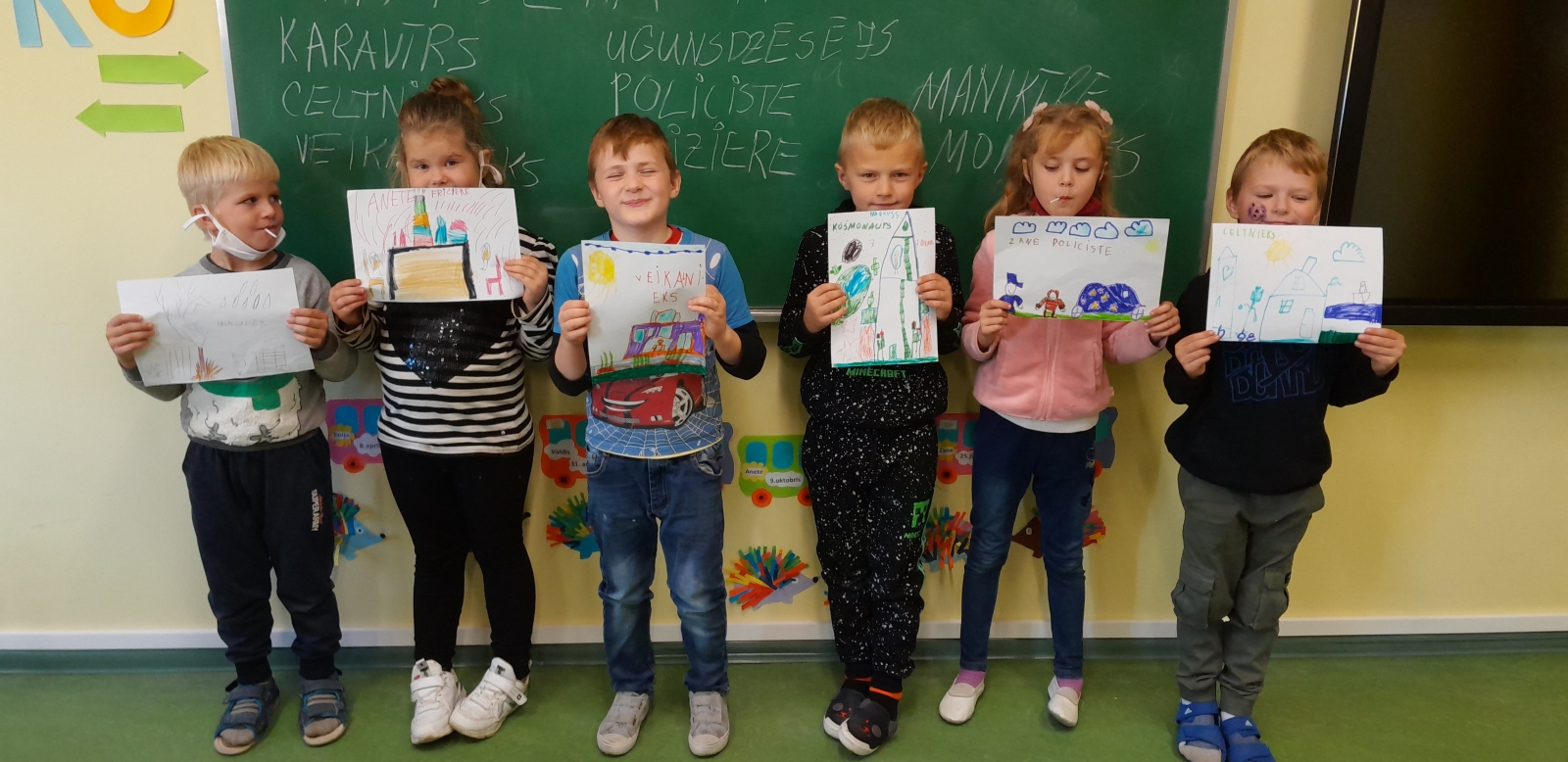 Bērni ar saviem zīmējumiem rokās