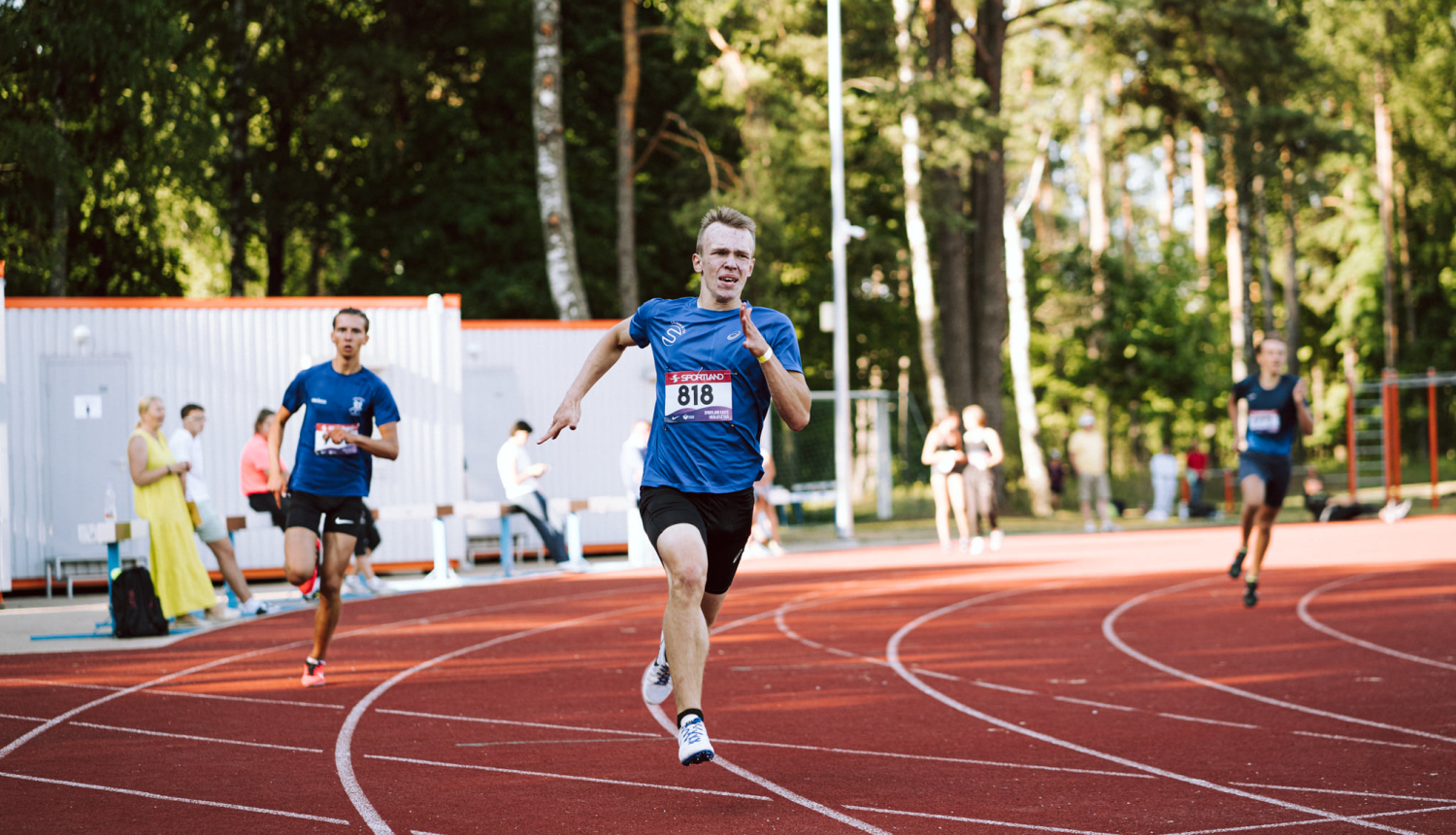 Jaunieši skrien stadionā (centrā Nīls Jakovels)