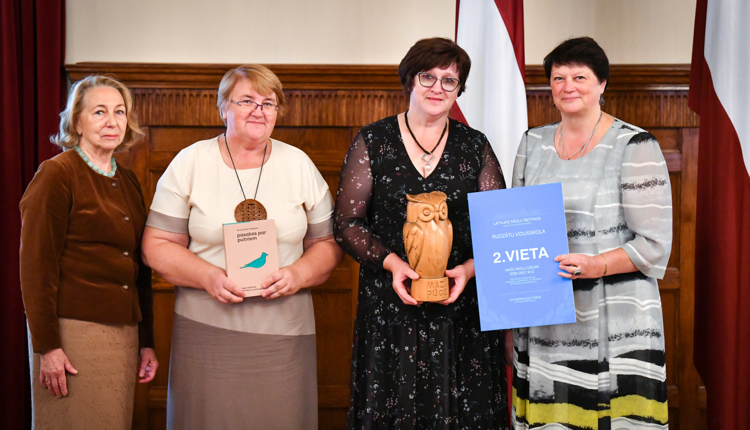 Četras sievietes ar koka pūci un diplomu