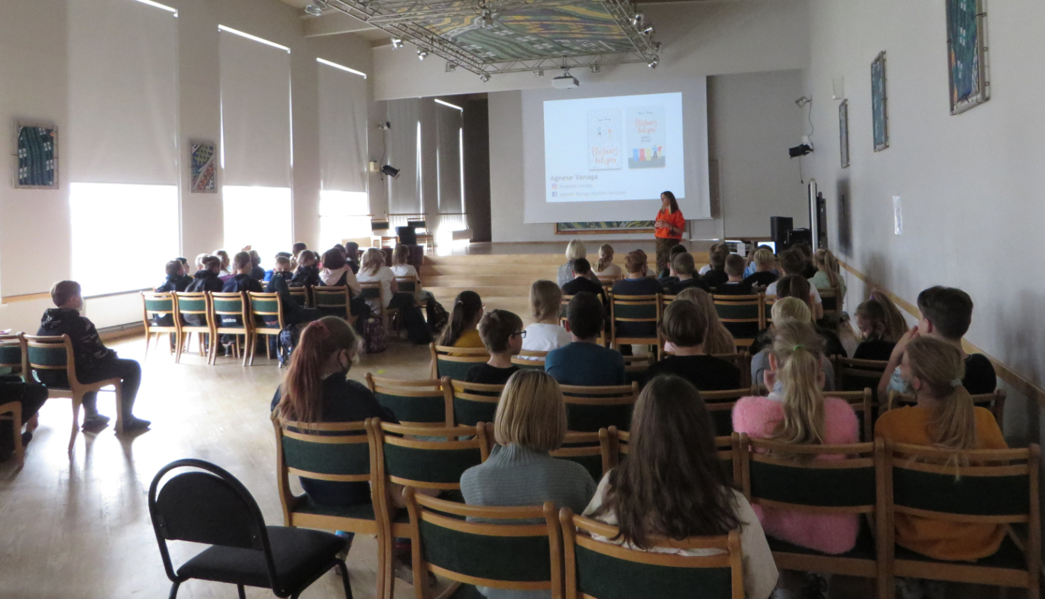 Zālē sēž cilvēki