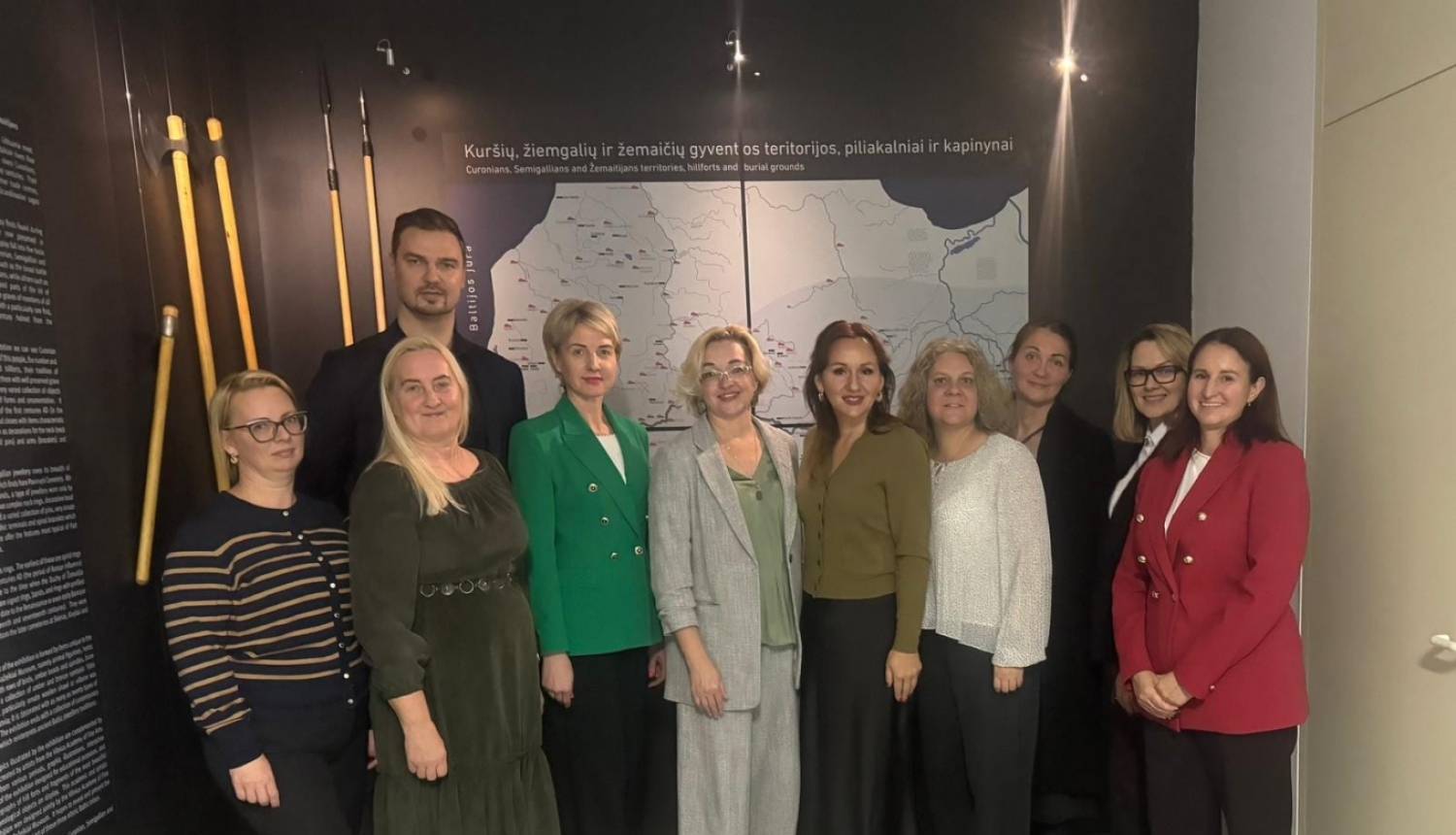 daudz cilvēki sastājušies rindā pozē