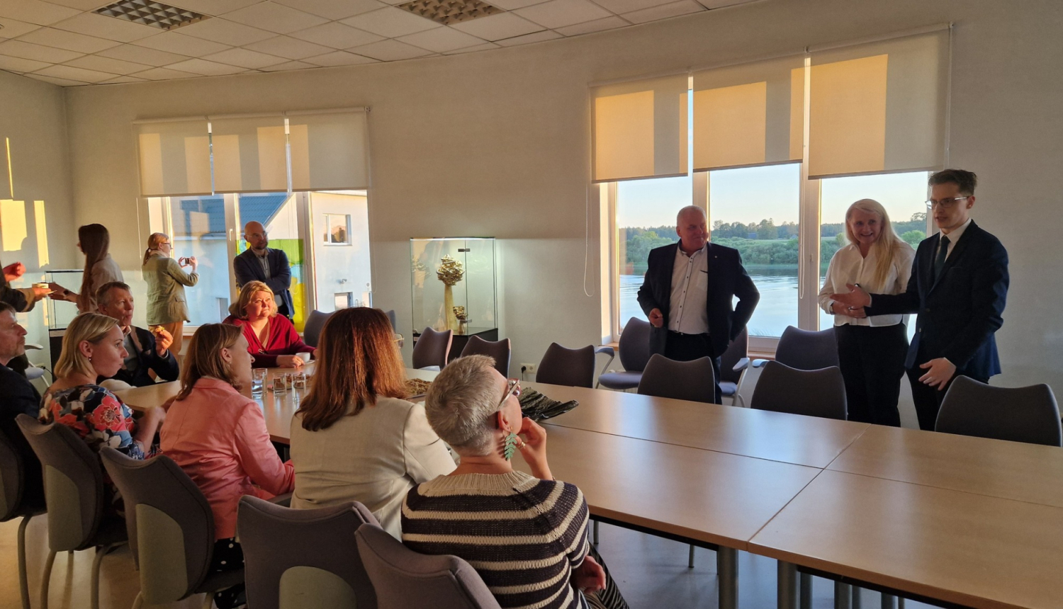 daudz cilvēku sēž ap galdu