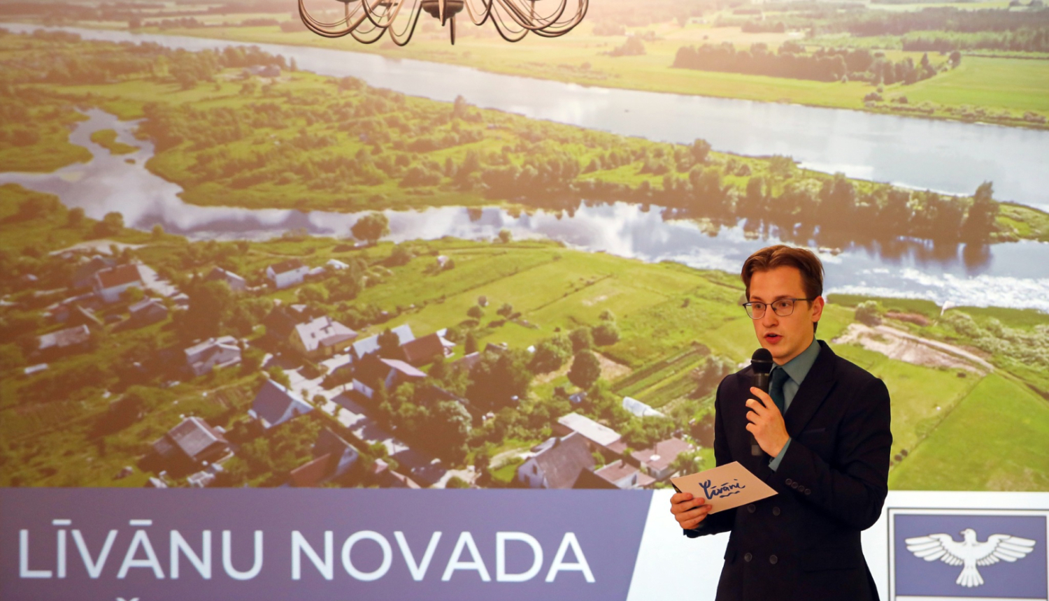 vīrietis prezentē ar mikrofonu