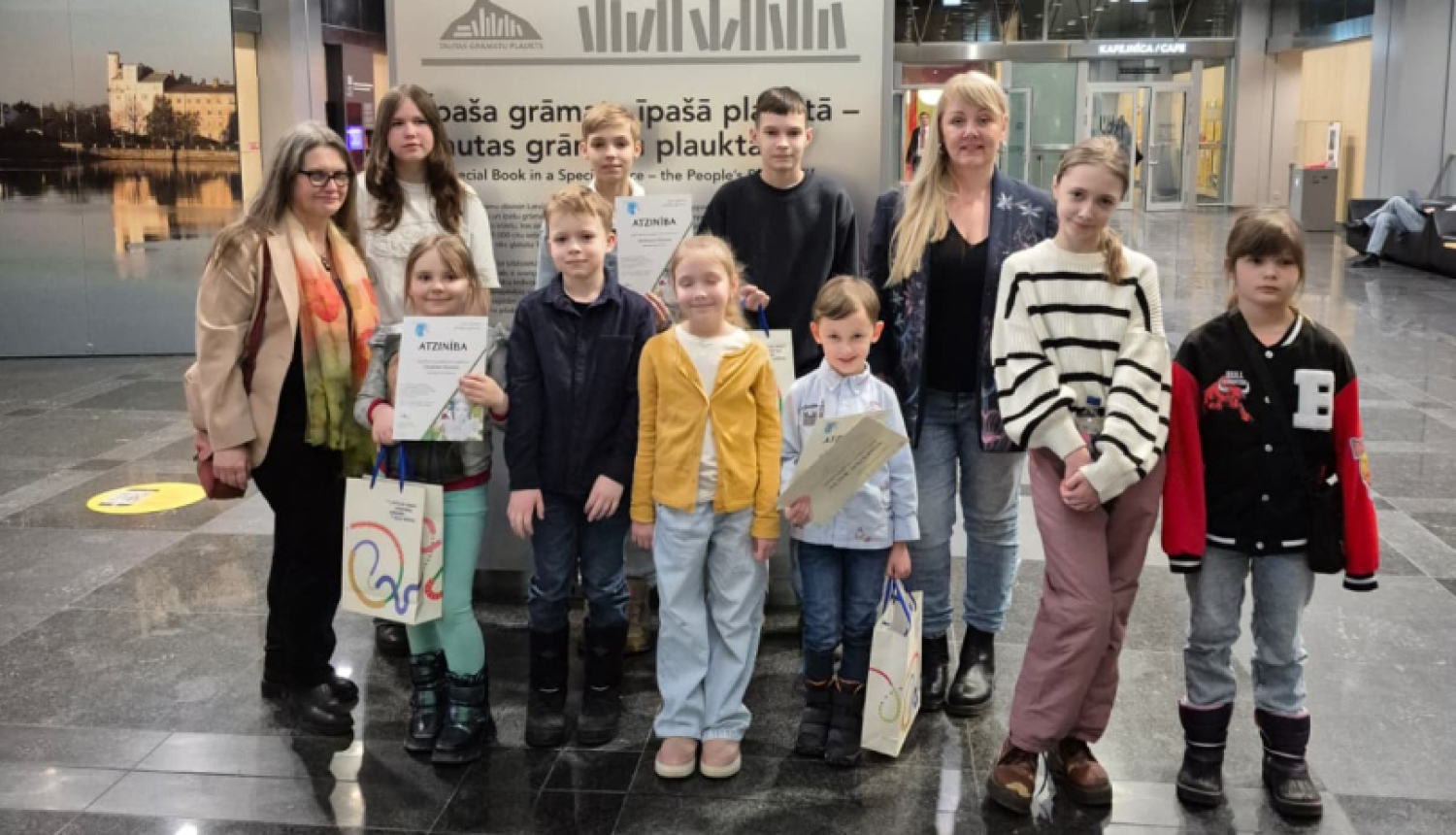 daudz bērnu grupiņā pozē