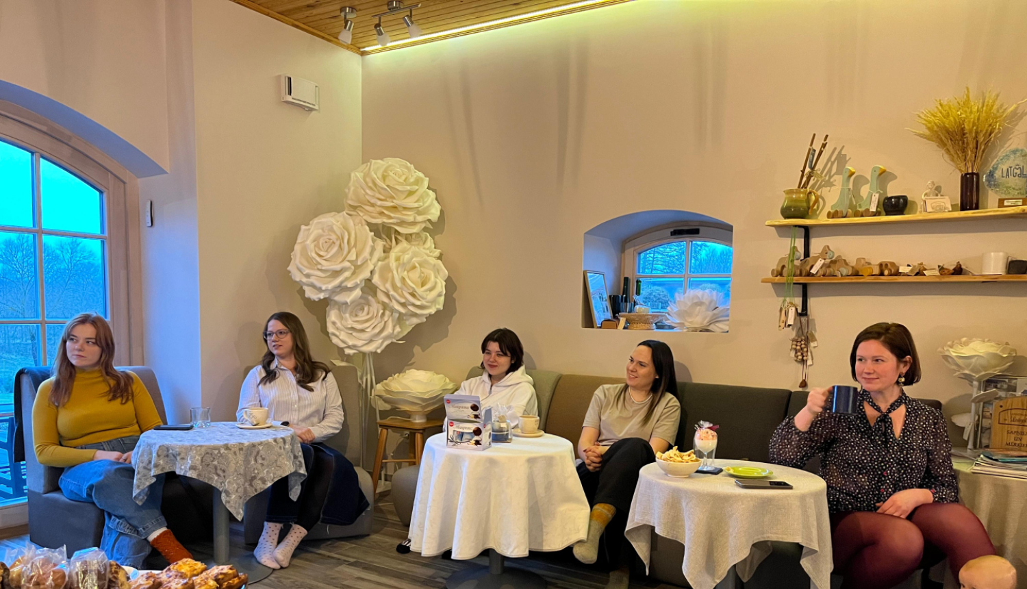 cilvēki sēž ap galdu