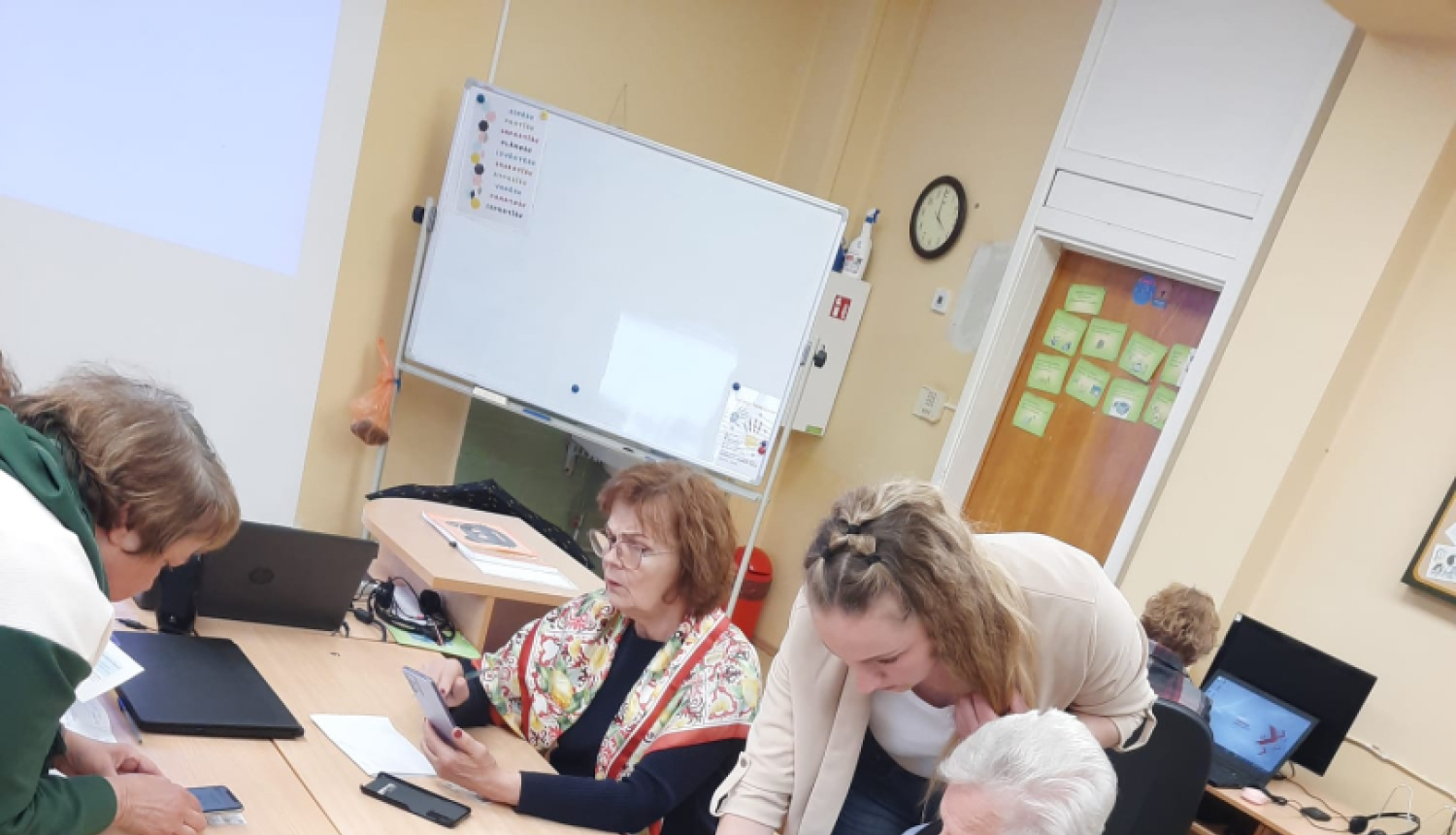 daudz cilvēki mācās ap galdu