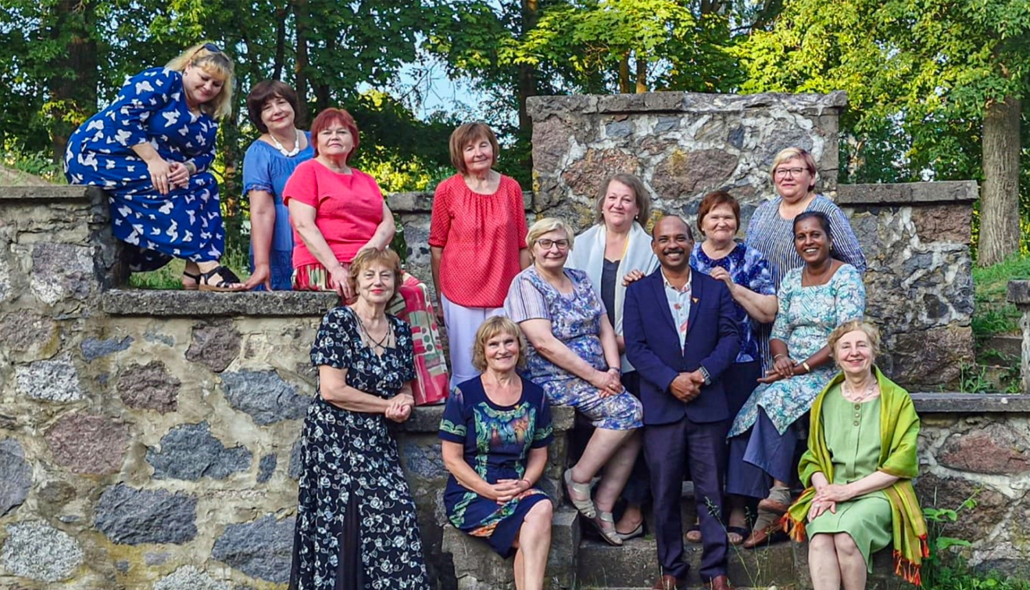 daudz cilvēki stāv pie akmeņu sienas