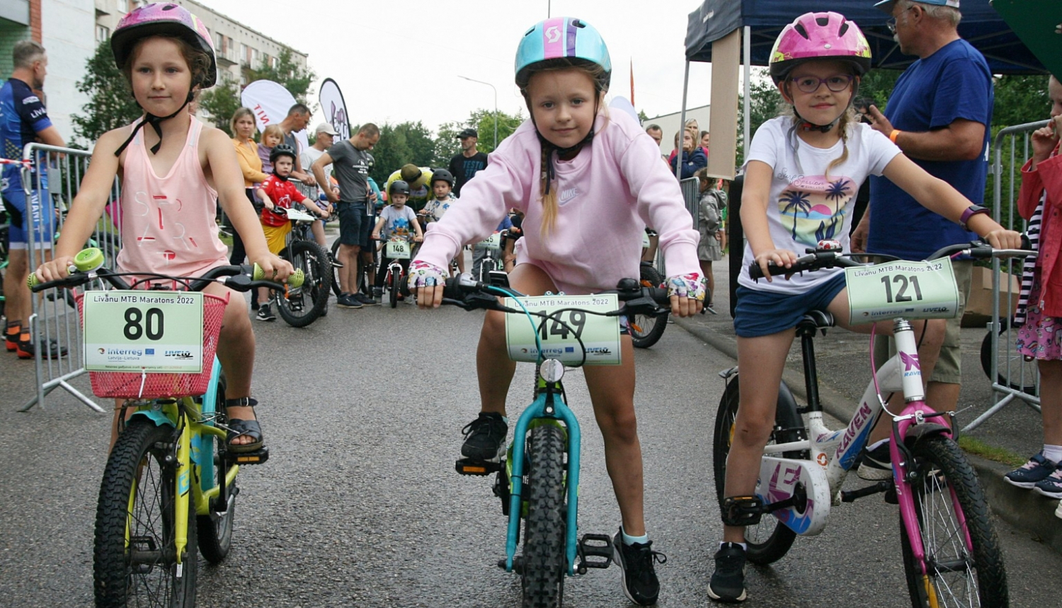 trīs bērni ar velosipēdiem