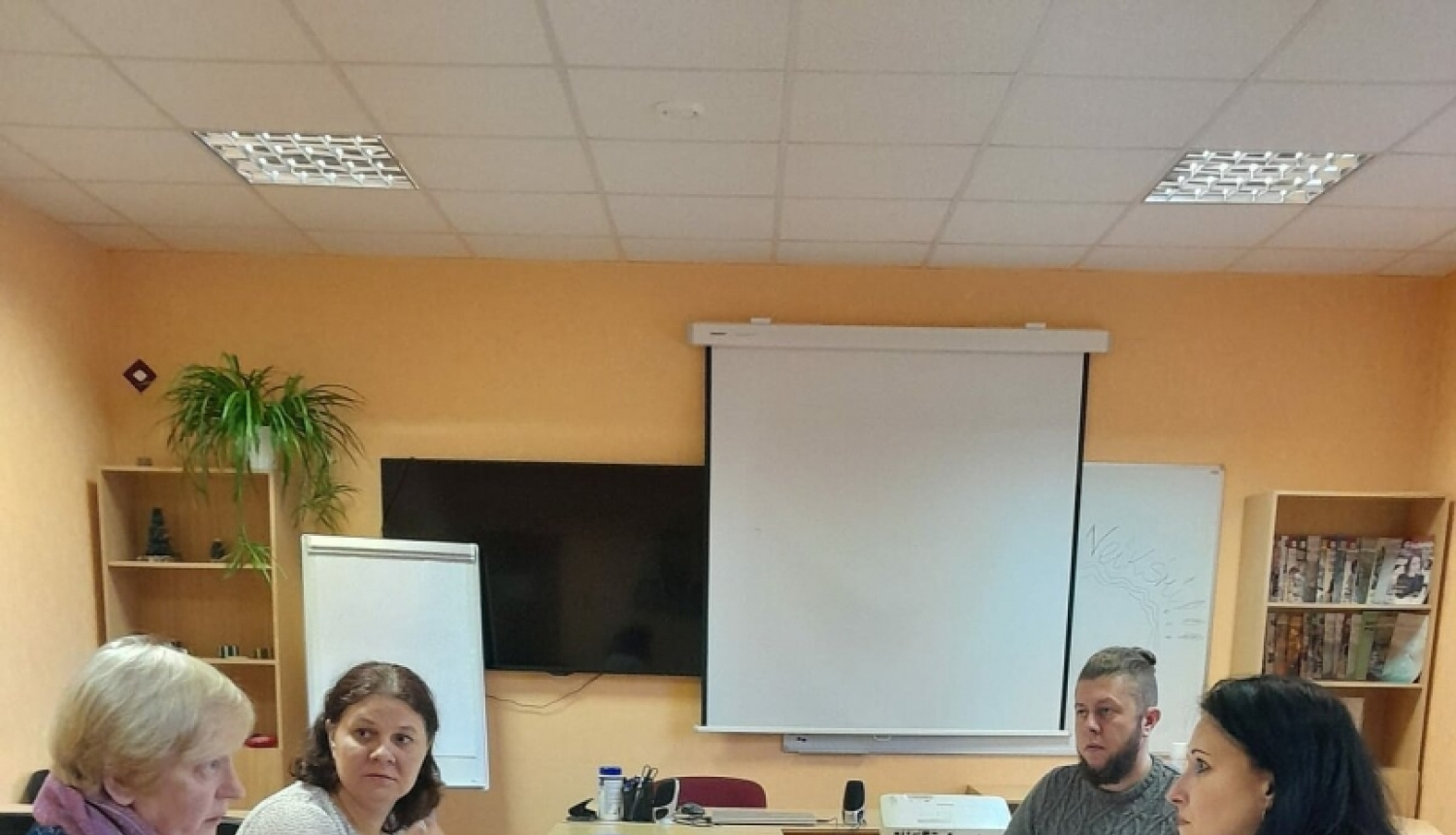 daudz cilvēku apspriedē ap galdu