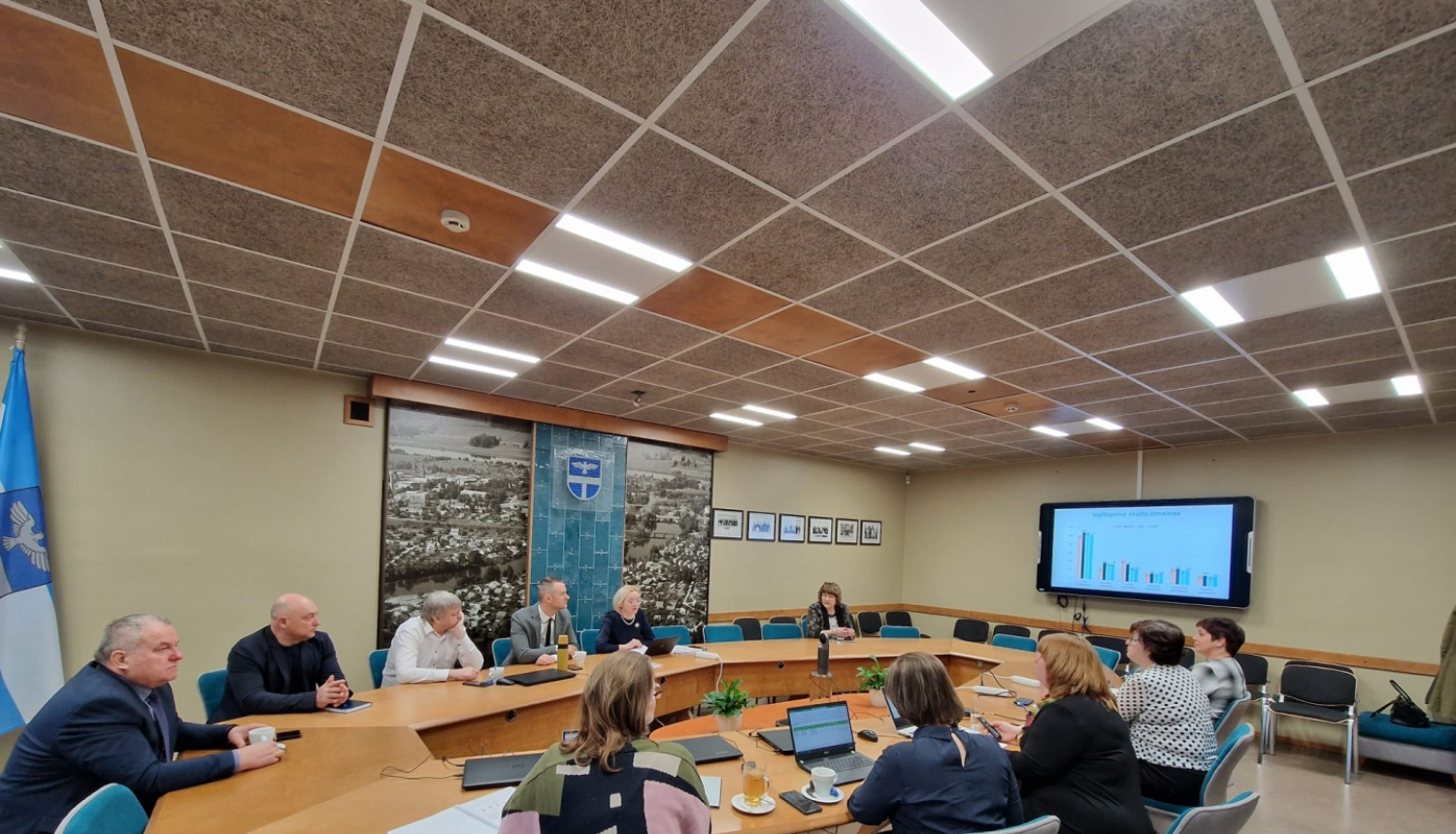 vairāki cilvēki sēž ap apaļo galdu apspriede