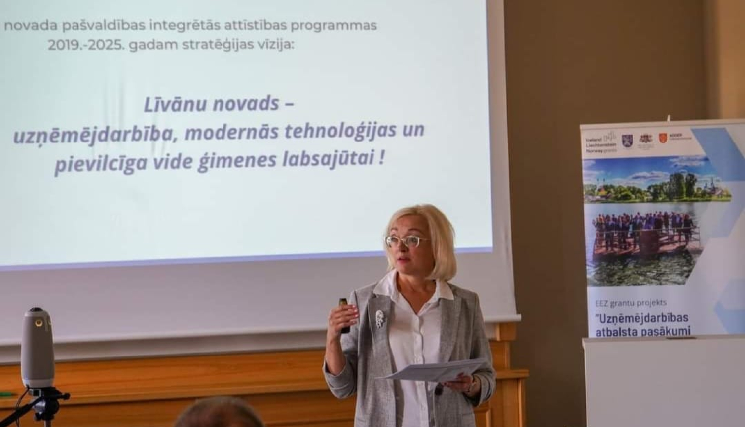 sieviete uzstājas pie prezentācijas