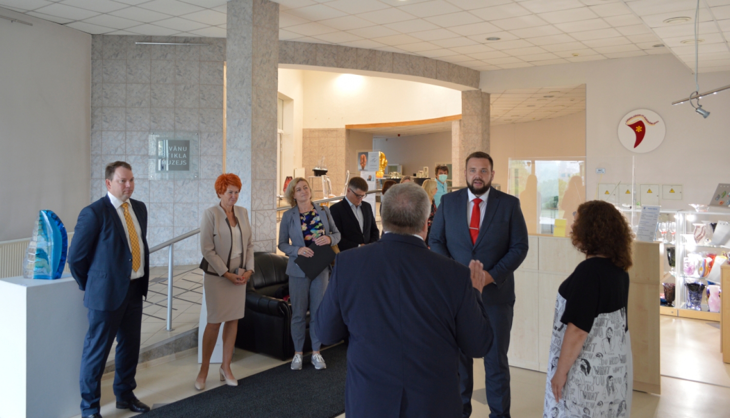 Ekonomikas ministra vizīte Līvānos - cilvēki stāv Līvānu stikla un amatniecības centrā