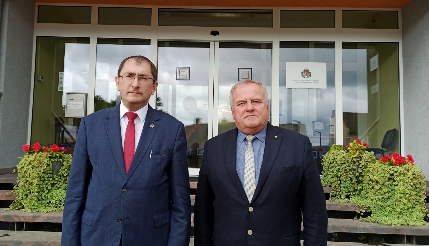 Satiksmes ministrs un domes priekšsēdētājs pie Līvānu novada domes ieejas