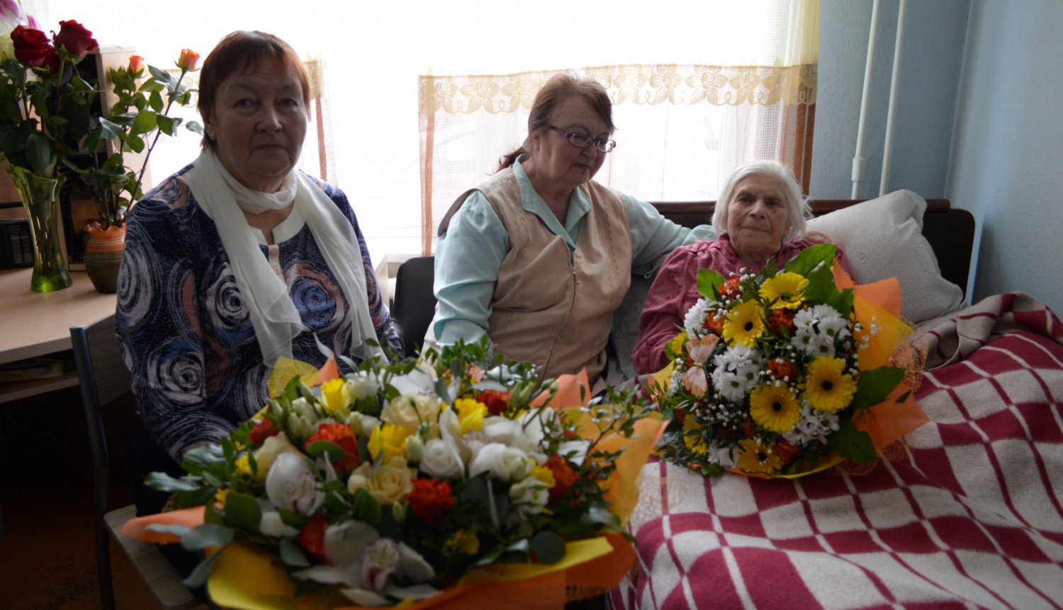 Trīs sievietes ar ziediem