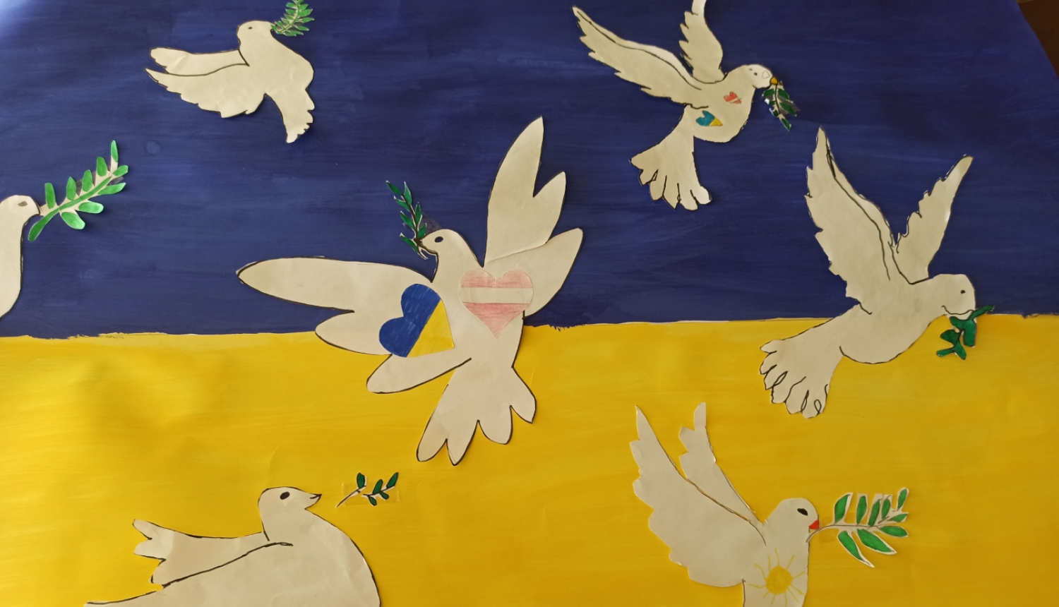 Bērnu zīmējums ar Ukrainas karogu un miera baložiem