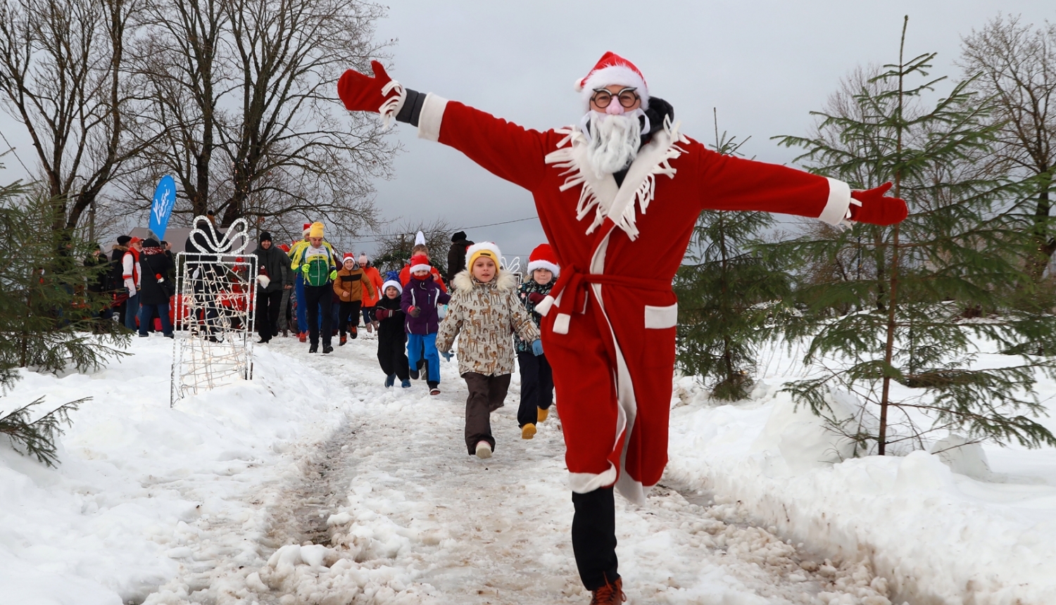 ziemassvētku vecītis skrien pa priekšu un iedzīvotāji aiz viņa