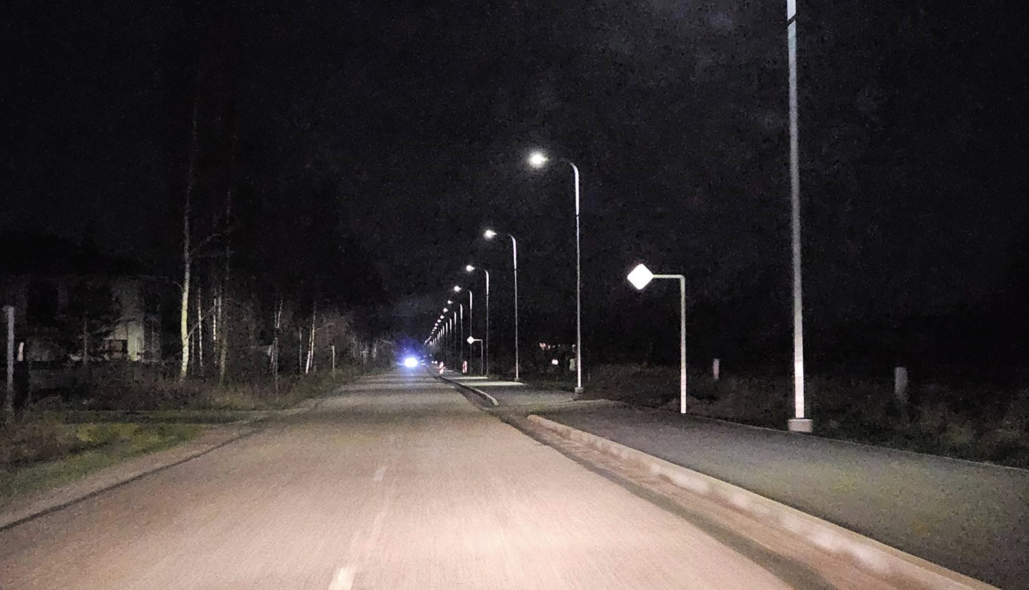 Iela nakts laikā ar ieslēgtām laternām